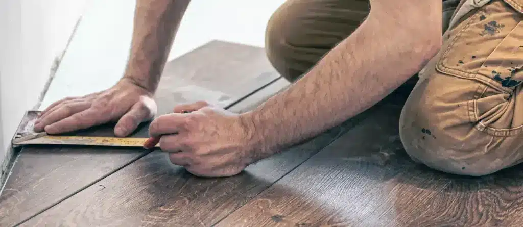 male worker puts laminate flooring floor e1716892853928